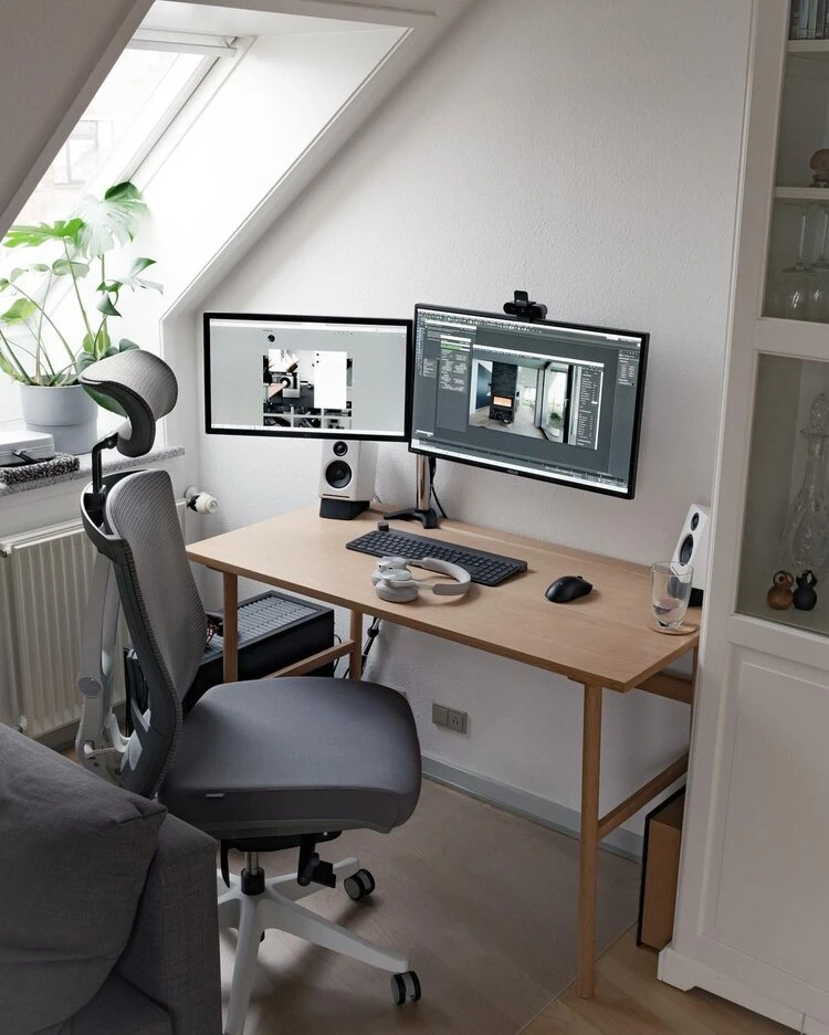 Jensen's Scandinavian-minimalist desk setup in Denmark featuring dual monitors, a mechanical keyboard, and a clean clutter-free workspace