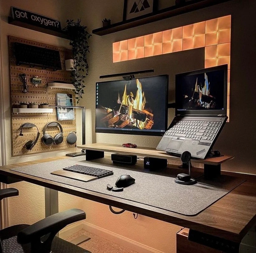 Teksetup's 2021 Copper Rhino Setup of the Year featuring warm ambient lighting, matching wood grain surfaces, a pegboard, and a cozy fireplace desktop wallpaper